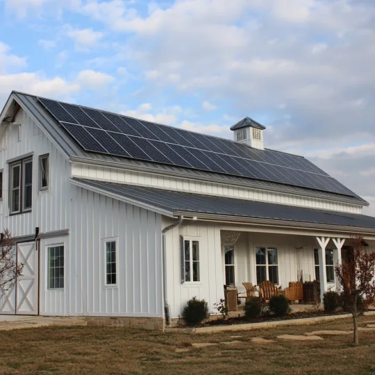 A modern barndominium equipped with rooftop solar panels, designed for energy efficiency and long term savings.