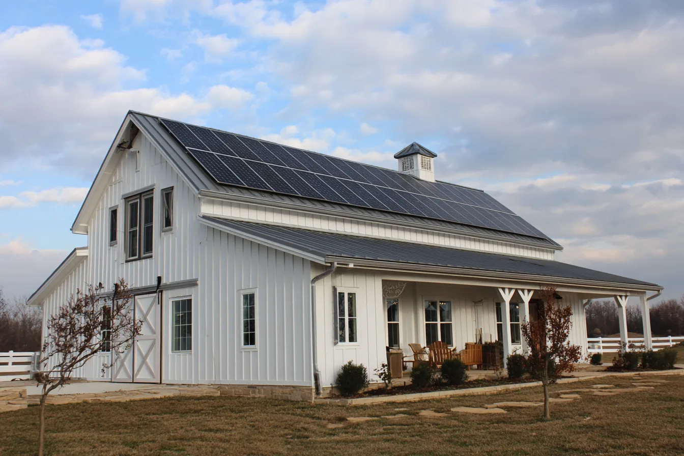 A modern barndominium equipped with rooftop solar panels, designed for energy efficiency and long term savings.