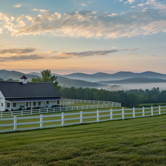 A white barndominium with a black metal roof on a sprawling green hill in rural Virginia, showing proper setback and zoning placement.